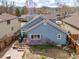 Backyard showcasing the home's blue exterior, patio, and landscaping with trees and mountains in the distance at 2590 S Independence St, Lakewood, CO 80227