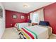 Cozy bedroom with twin beds, colorful bedding, and a window providing natural light at 2590 S Independence St, Lakewood, CO 80227
