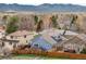 A backyard view of a charming house with a wooden fence, trees, and outdoor patio space at 2590 S Independence St, Lakewood, CO 80227