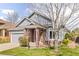 Well-maintained home with brick and siding exterior, featuring a neatly landscaped lawn and mature tree at 2590 S Independence St, Lakewood, CO 80227