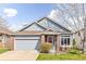 Charming single-Gathering home featuring blue siding, brick accents, and an attached two-car garage at 2590 S Independence St, Lakewood, CO 80227