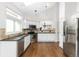 Well-lit kitchen with white cabinets, stainless steel appliances, and hardwood flooring at 2590 S Independence St, Lakewood, CO 80227