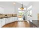 Bright kitchen area with white cabinetry, granite countertops and a sliding door to backyard at 2590 S Independence St, Lakewood, CO 80227