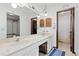 Bathroom with a marble double vanity, mirrors, and a door to the right leading to a bathtub and shower at 3907 E 133Rd Ct, Thornton, CO 80241