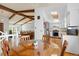 Bright dining area showcasing a wood table, hardwood floors, and vaulted ceilings with exposed beams at 3907 E 133Rd Ct, Thornton, CO 80241