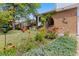 Landscaped front yard with colorful flowers and lush greenery leading to the brick facade home with an arched entryway at 3907 E 133Rd Ct, Thornton, CO 80241
