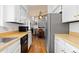 Functional kitchen with white cabinets, wood countertops, black dishwasher, and an open view to the dining area at 3907 E 133Rd Ct, Thornton, CO 80241