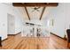 Bright living room featuring wood floors, beamed ceilings, and an open railing, creating a warm and inviting atmosphere at 3907 E 133Rd Ct, Thornton, CO 80241