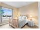 Well-lit bedroom with a wooden bed frame, soft carpet, and a large window providing natural light at 10111 Inverness Main St # 312, Englewood, CO 80112
