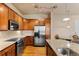 Well-lit kitchen features stainless steel appliances and abundant wooden cabinetry at 10111 Inverness Main St # 312, Englewood, CO 80112