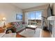Bright living room with couch, telescope, fireplace, and view of city buildings at 10111 Inverness Main St # 312, Englewood, CO 80112