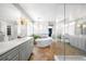 Bright bathroom with a soaking tub, walk-in shower and dual vanities with herringbone tile floors at 8390 Coyote Dr, Castle Pines, CO 80108