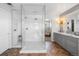 Bathroom with herringbone floors, a large glass enclosed shower and double vanity sinks at 8390 Coyote Dr, Castle Pines, CO 80108