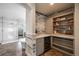 Bathroom with custom built in shelving, wine cooler, and a glass shower at 8390 Coyote Dr, Castle Pines, CO 80108