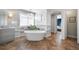 Elegant bathroom featuring a freestanding tub, herringbone floors, and modern lighting at 8390 Coyote Dr, Castle Pines, CO 80108