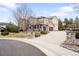Spacious driveway leading to a three-car garage, complemented by lush landscaping and a basketball hoop at 8390 Coyote Dr, Castle Pines, CO 80108