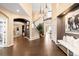 Inviting foyer with hardwood floors, a grand staircase, designer lighting, and stylish decor at 8390 Coyote Dr, Castle Pines, CO 80108