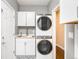 Bright laundry room with stacked washer/dryer, white cabinets and butcher block countertop at 8390 Coyote Dr, Castle Pines, CO 80108
