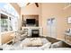 Cozy living room with a fireplace, high ceilings, large windows, and stylish furnishings at 8390 Coyote Dr, Castle Pines, CO 80108