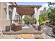 Expansive outdoor living space featuring dining, seating, a swing, waterfall and a pergola at 8390 Coyote Dr, Castle Pines, CO 80108