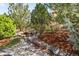 Backyard water feature featuring a small waterfall, rocks, lush landscaping and mature trees at 8390 Coyote Dr, Castle Pines, CO 80108