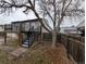 Backyard view of the house with a deck and stairs going down to the yard at 220 Mckinley Dr, Bennett, CO 80102