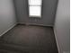 An empty carpeted bedroom with gray walls and a window at 220 Mckinley Dr, Bennett, CO 80102