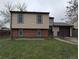 Charming two-story home featuring tan siding, brick accents, and an attached one-car garage at 220 Mckinley Dr, Bennett, CO 80102