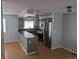 Open-concept kitchen featuring stainless steel appliances and sleek gray cabinets at 220 Mckinley Dr, Bennett, CO 80102