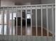 View from stairway landing with wooden floors and a glimpse of the kitchen and a room with doors at 220 Mckinley Dr, Bennett, CO 80102