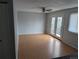 An empty living room featuring laminated floors, a ceiling fan, and access to a patio at 220 Mckinley Dr, Bennett, CO 80102