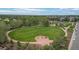 A winding trail surrounds a green lawn with an open play area, bordered by trees and community buildings in the distance at 9300 E Florida Ave # 1202, Denver, CO 80247