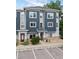 Modern townhouse showcasing a blue and gray exterior, red doors, and well-maintained landscaping at 9300 E Florida Ave # 1202, Denver, CO 80247