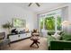 Bright living room featuring a comfortable green sofa, large windows, and modern furnishings at 9300 E Florida Ave # 1202, Denver, CO 80247