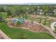 Aerial view of colorful community playground featuring slides, swings, and covered seating areas with walking paths at 9300 E Florida Ave # 1202, Denver, CO 80247