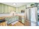 Modern kitchen with stainless steel appliances, sage cabinets, and butcher block countertops at 3080 N Cook St, Denver, CO 80205