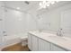 Bright bathroom with double sinks, white cabinetry, and a tile tub-shower combo at 45927 Wood Thrush Ave, Bennett, CO 80102