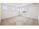 Empty bedroom with carpet, three windows, white walls, and natural light streaming in at 45927 Wood Thrush Ave, Bennett, CO 80102
