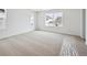 Carpeted bedroom with natural light, and two windows showcasing a glimpse of neighborhood at 45927 Wood Thrush Ave, Bennett, CO 80102