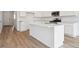 Open kitchen design with island, stainless steel appliances, and modern white cabinetry at 45927 Wood Thrush Ave, Bennett, CO 80102