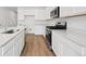 Modern kitchen featuring white cabinets, countertops, and stainless steel appliances at 45927 Wood Thrush Ave, Bennett, CO 80102