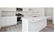 Kitchen features a white island, modern stainless steel appliances, white shaker cabinets, and vinyl flooring at 45927 Wood Thrush Ave, Bennett, CO 80102