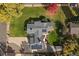 Aerial view of a home with solar panels, lush green lawn, mature trees, and inviting backyard patio at 34 Skyline Dr, Wheat Ridge, CO 80215