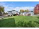 Well-manicured backyard with a spacious lawn, deck, patio, and lovely landscaping at 34 Skyline Dr, Wheat Ridge, CO 80215