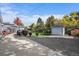 Expansive backyard with large driveway, detached garage, lush greenery and patio furniture at 34 Skyline Dr, Wheat Ridge, CO 80215