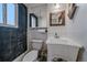 Compact bathroom featuring textured wall, mirrored cabinet and sink with faucet at 34 Skyline Dr, Wheat Ridge, CO 80215
