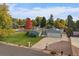 Charming single-story home with an attached two car garage, solar panels, and lush green lawn at 34 Skyline Dr, Wheat Ridge, CO 80215