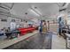 Spacious garage featuring an automobile lift, work space, and vintage red and black pick up truck at 34 Skyline Dr, Wheat Ridge, CO 80215