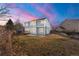 Spacious backyard with lush grass, a wooden deck, and privacy fencing with blue siding at 5604 S Shawnee St, Aurora, CO 80015