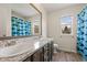 Bathroom featuring a double vanity, framed mirror, and shower with shark themed shower curtain at 5604 S Shawnee St, Aurora, CO 80015